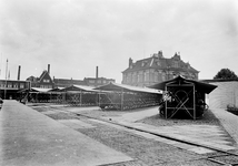 839195 Gezicht op het terrein van de hoofdwerkplaats Haarlem van de N.S., met de rijwielstallingen voor het personeel.